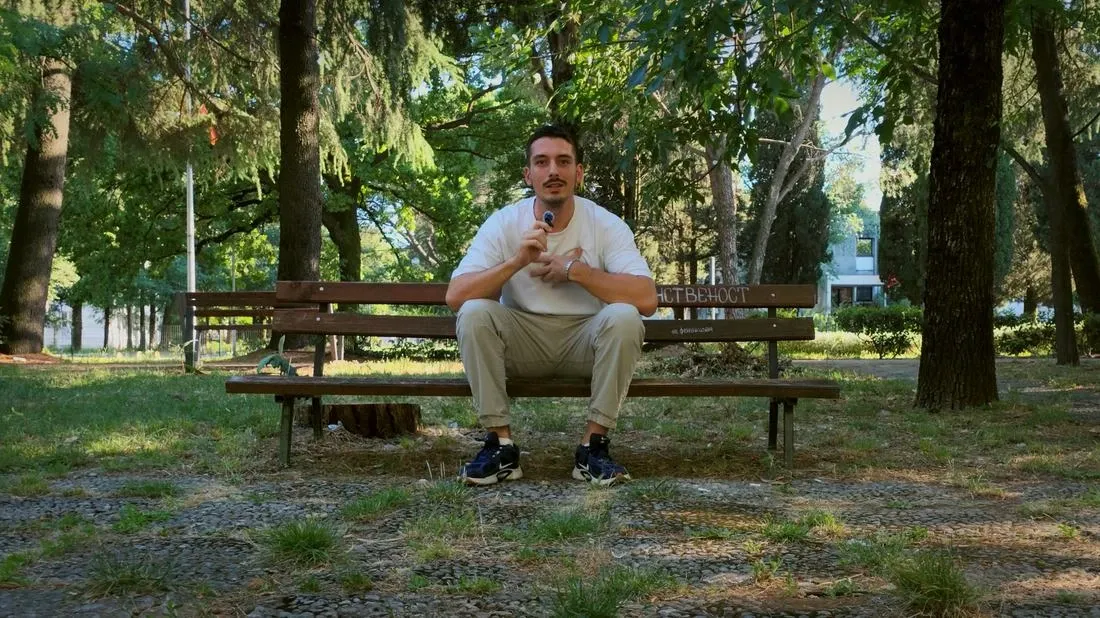 Mihailo, founder of Nothin, talking to camera in a park in Podgorica